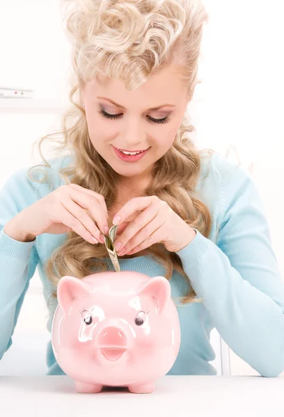 Lovely woman with piggy bank and money Stock Photo