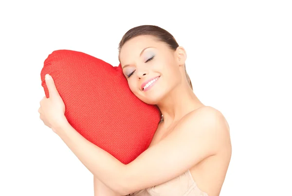 Kvinna med röd hjärtformad kudde över vita — Stockfoto