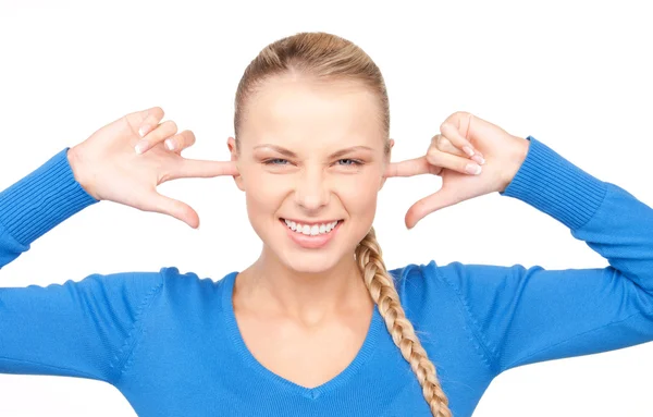 Smiling woman with fingers in ears — Stockfoto