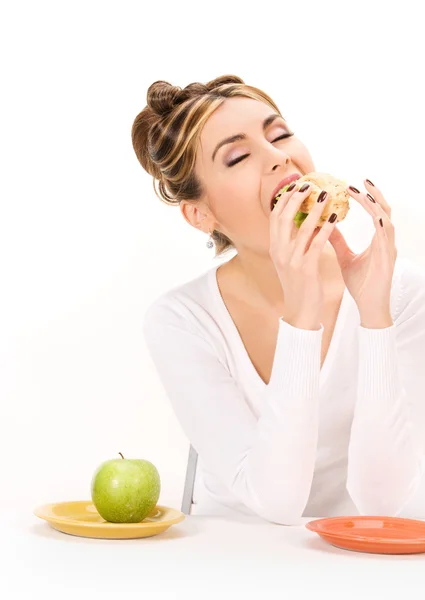 Mulher com maçã verde e sanduíche — Fotografia de Stock