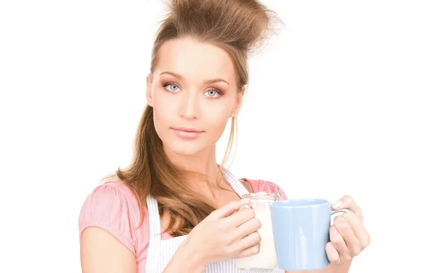 Femme au foyer avec lait et tasse — Photo
