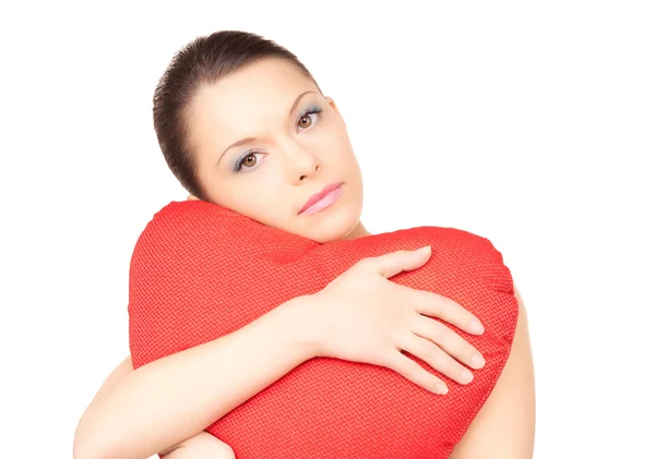 Жінка з червоною подушкою у формі серця над білим — стокове фото