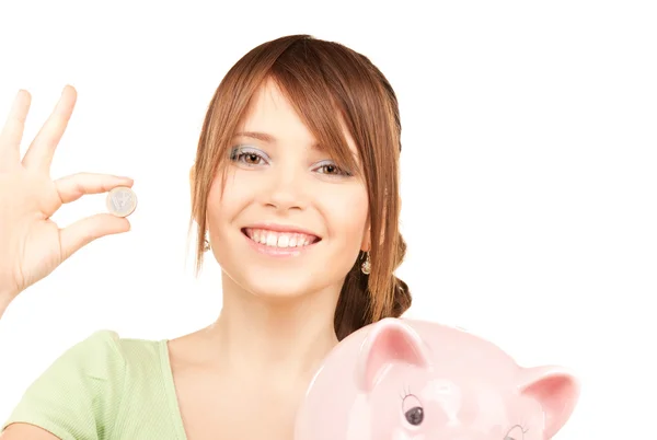 Linda menina adolescente com banco porquinho e moeda — Fotografia de Stock
