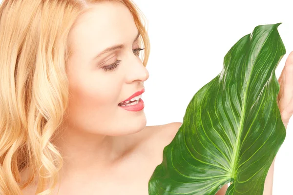 Женщина с зеленым листом на белом — стоковое фото