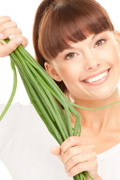 Beautiful housewife with spring onions over white — Stock Photo, Image
