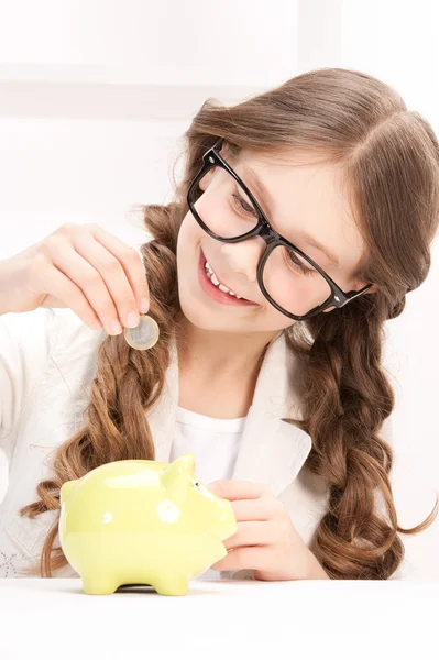 Little girl with piggy bank and coin — Stock Photo, Image