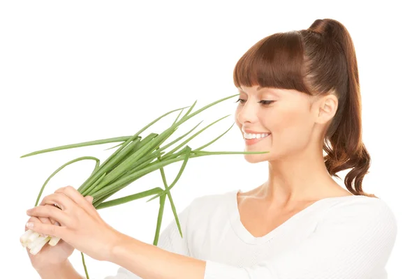 Beautiful housewife with spring onions over white — Stock Photo, Image