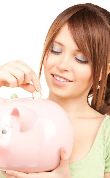 Linda menina adolescente com banco porquinho e moeda — Fotografia de Stock