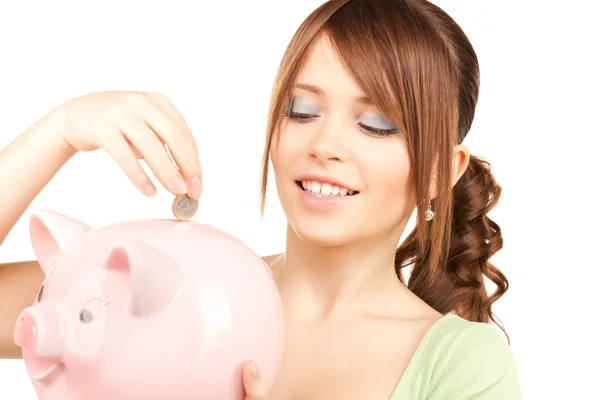 Lovely teenage girl with piggy bank and coin Stock Image