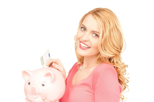 Mooie vrouw met piggy bank en geld Stockfoto