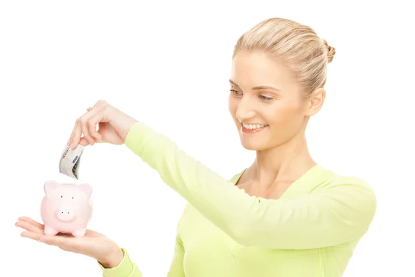 Vrouw met piggy bank en geld — Stockfoto