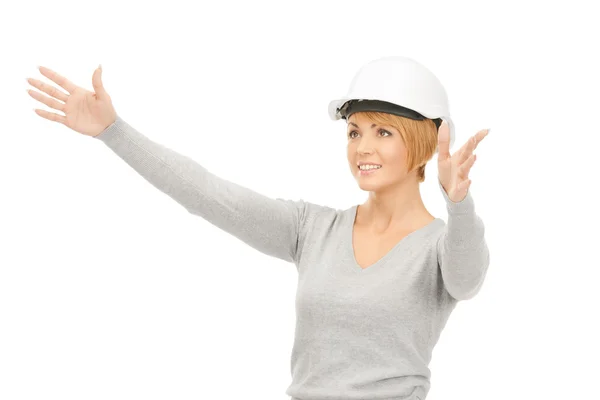 Female contractor in helmet working with something imaginary — Stock Photo, Image