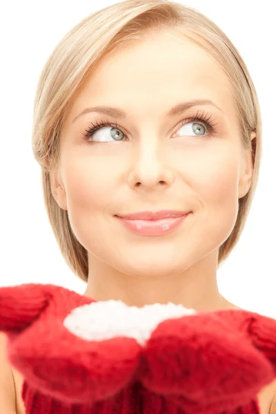 Schöne Frau in roten Fäustlingen mit Schnee lizenzfreie Stockbilder