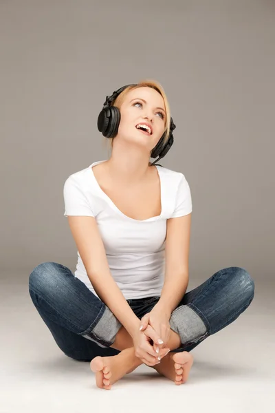 Glad tonårsflicka i stora hörlurar — Stockfoto
