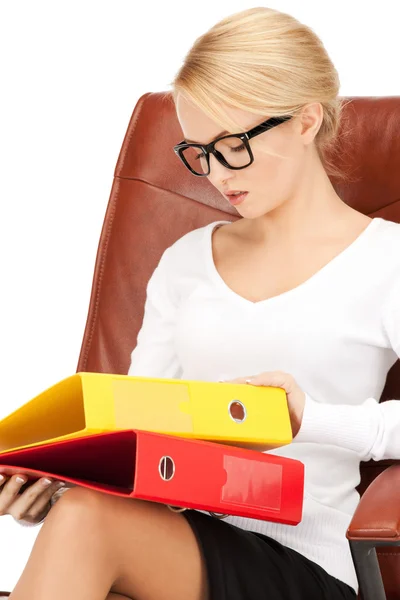 Jonge zakenvrouw met mappen zittend in stoel — Stockfoto
