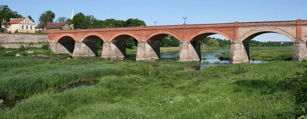 Gammal tegel bro i Kuldīga, Lettland Royaltyfria Stockfoton