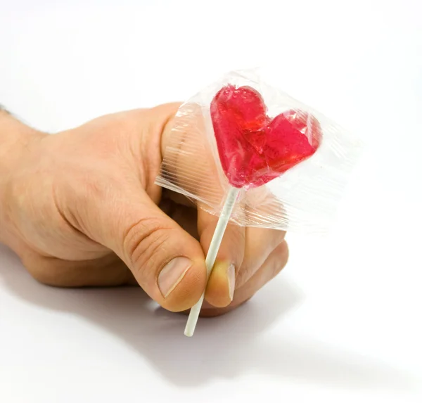Mão humana segurando doces em forma de coração — Fotografia de Stock