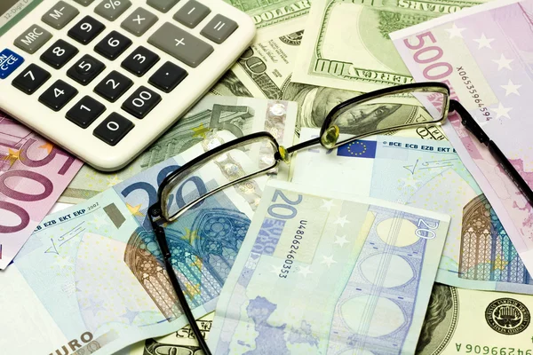 Dollar, euro-bankbiljetten, rekenmachine en glazen — Stockfoto