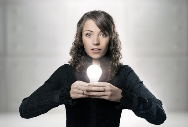 Молода дівчина тримає лампочку — стокове фото