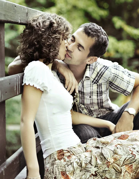 Молодая пара целуется на природе - вид сбоку . — стоковое фото