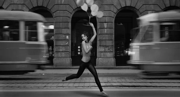stock image Fine art photo- young woman holding balloons in a empty city street