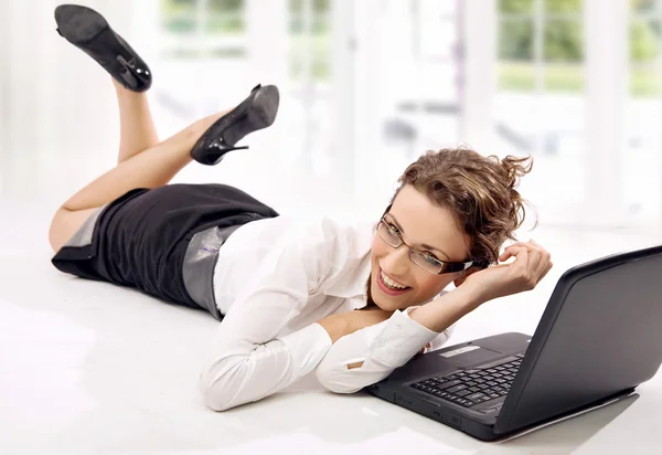 Giovane donna d'affari felice con il computer portatile sul pavimento — Foto Stock