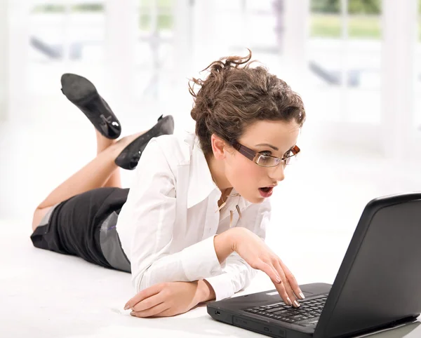 Счастливая молодая деловая женщина с ноутбуком на полу — стоковое фото