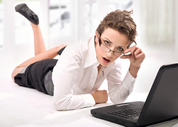 Glückliche junge Geschäftsfrau mit Laptop auf dem Fußboden — Stockfoto