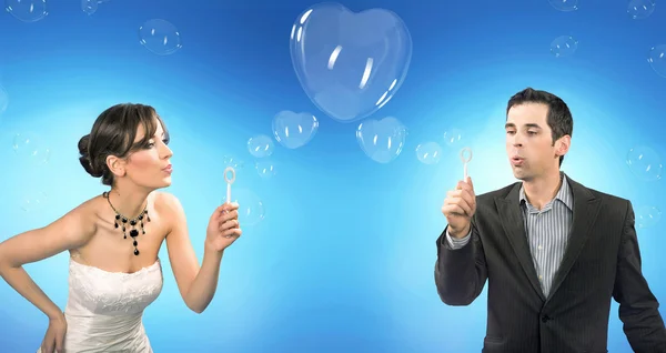 Casamento casal soprando coração em forma de bolhas de sabão romântico — Fotografia de Stock