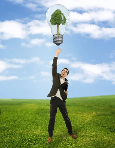 Empresário atingindo símbolo de energia verde — Fotografia de Stock