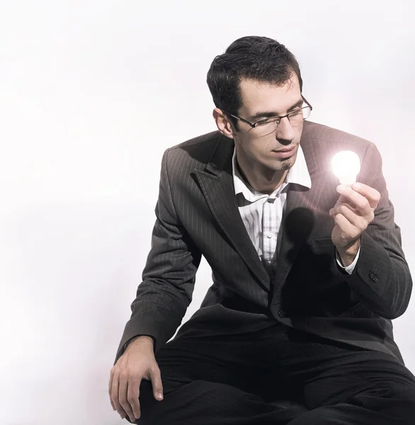 Podnikatel drží žárovku — Stock fotografie