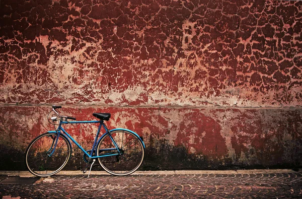 Old retro bicycle over grungy wall — Stock Photo, Image