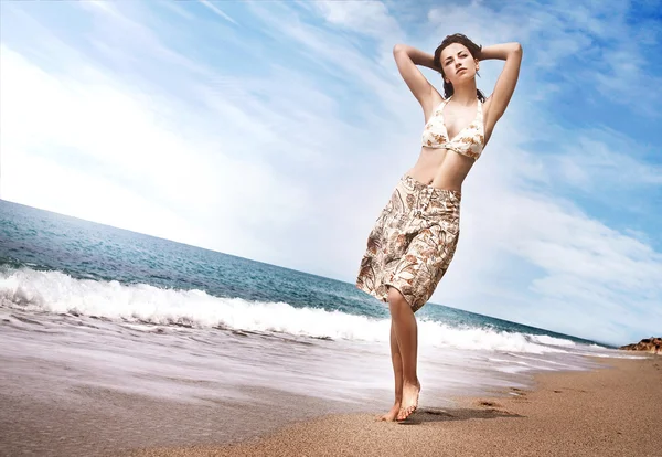 Vacker ung flicka som promenerar på stranden — Stockfoto