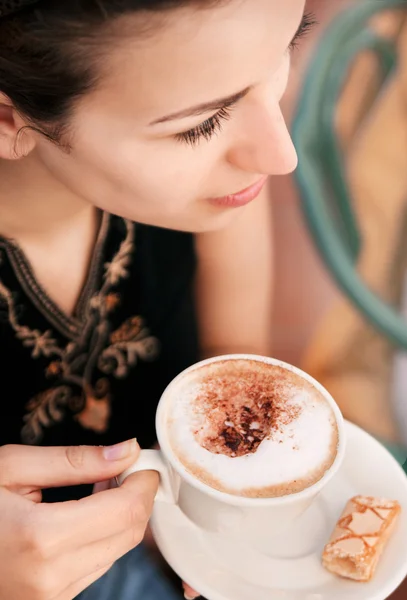 Молодая женщина наслаждается кофе-брейком Стоковое Изображение