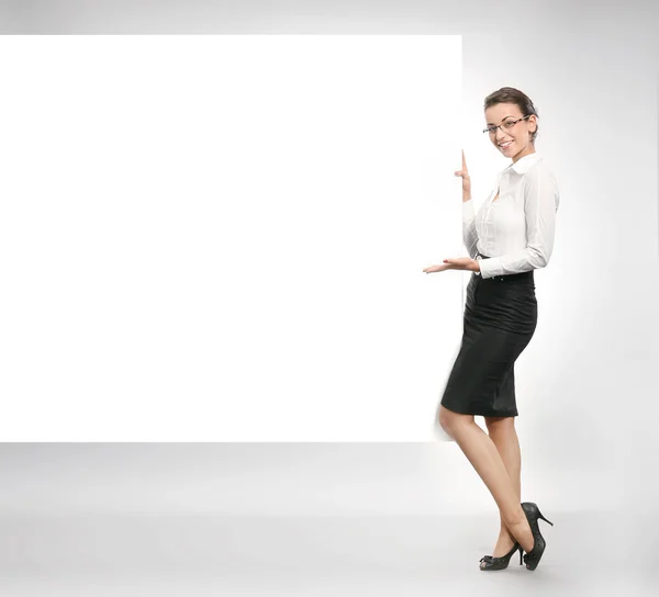 Schöne Geschäftsfrau zeigt leere weiße Tafel — Stockfoto