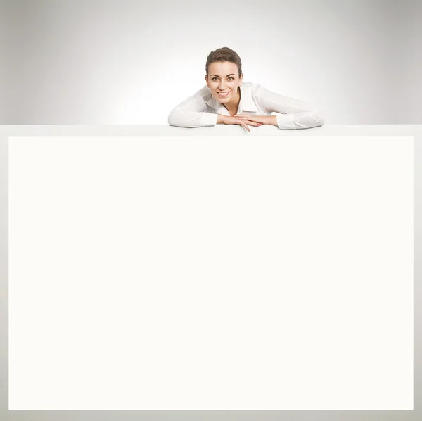 Mooie zakenvrouw tonen leeg wit bord — Stockfoto