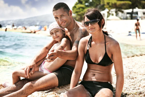 Счастливая семья на берегу океана — стоковое фото