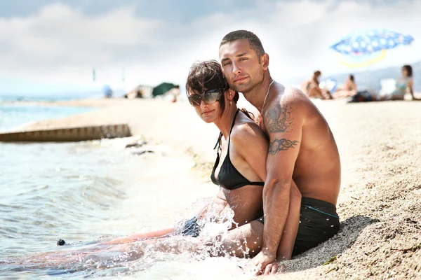 Attraktivt par avkopplande på stranden — Stockfoto