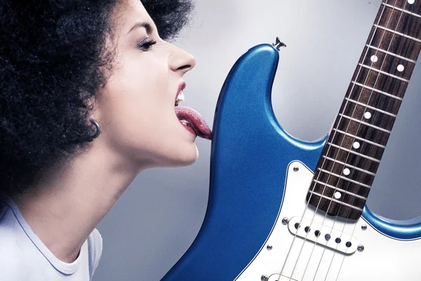 Красивая рок-н-ролльная девушка, облизывающая гитару — стоковое фото
