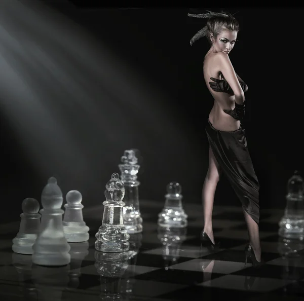 Mooie brunette staande op een schaakbord — Stockfoto