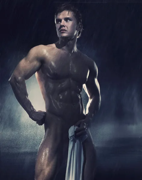 Ung snygg idrottsman stående i regnet — Stockfoto