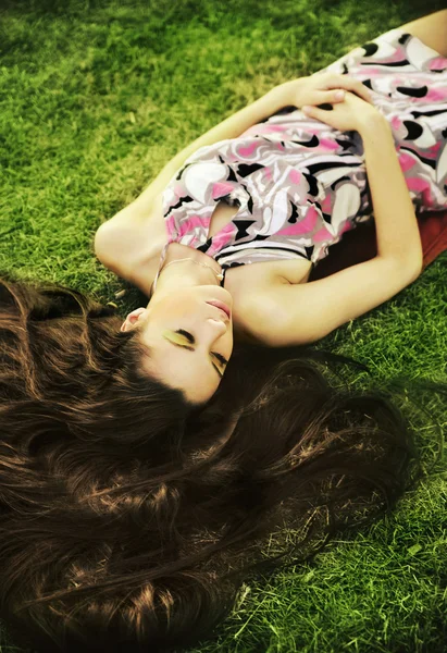 Брюнетка-красавица лежит на траве — стоковое фото