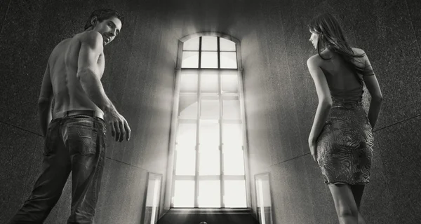Концептуальное изображение молодой пары, шагающей в окно света — стоковое фото