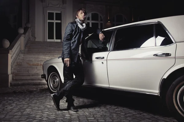 Stilig ung man står bredvid en limousine — Stock fotografie