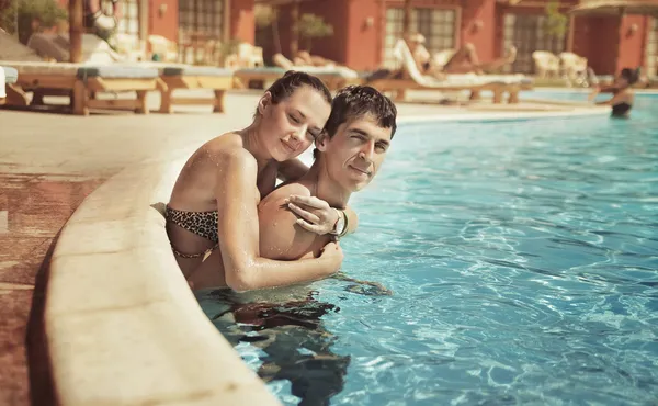 Pareja joven besándose en una piscina — Foto de Stock