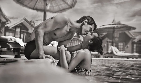 在一个游泳池接吻的年轻夫妇 — 图库照片