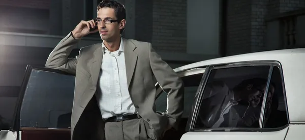 Jonge man spreken de telefoon naast de auto — Stockfoto
