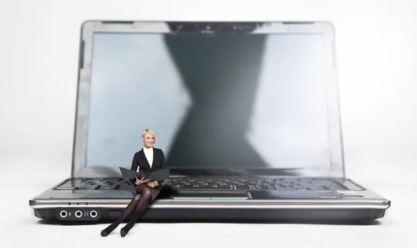 Giovane donna d'affari seduta su un computer portatile, isolata su bianco — Foto Stock