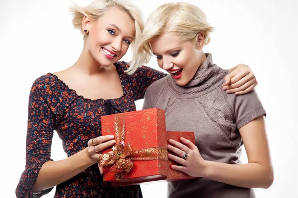 Two blond beauties holding a christmas present — Stock Photo, Image