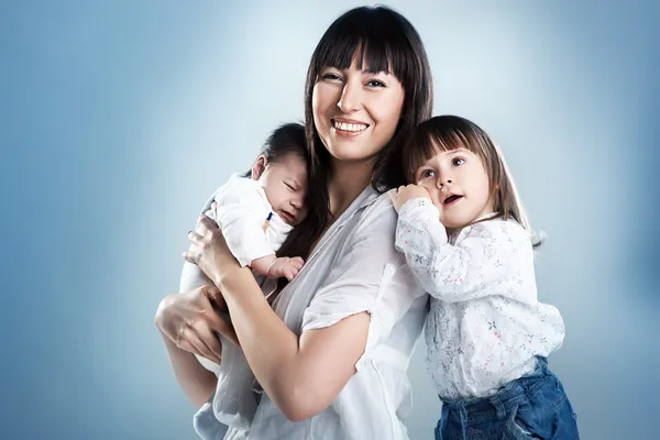 Loving mother holding son and daughter — Stock Photo, Image